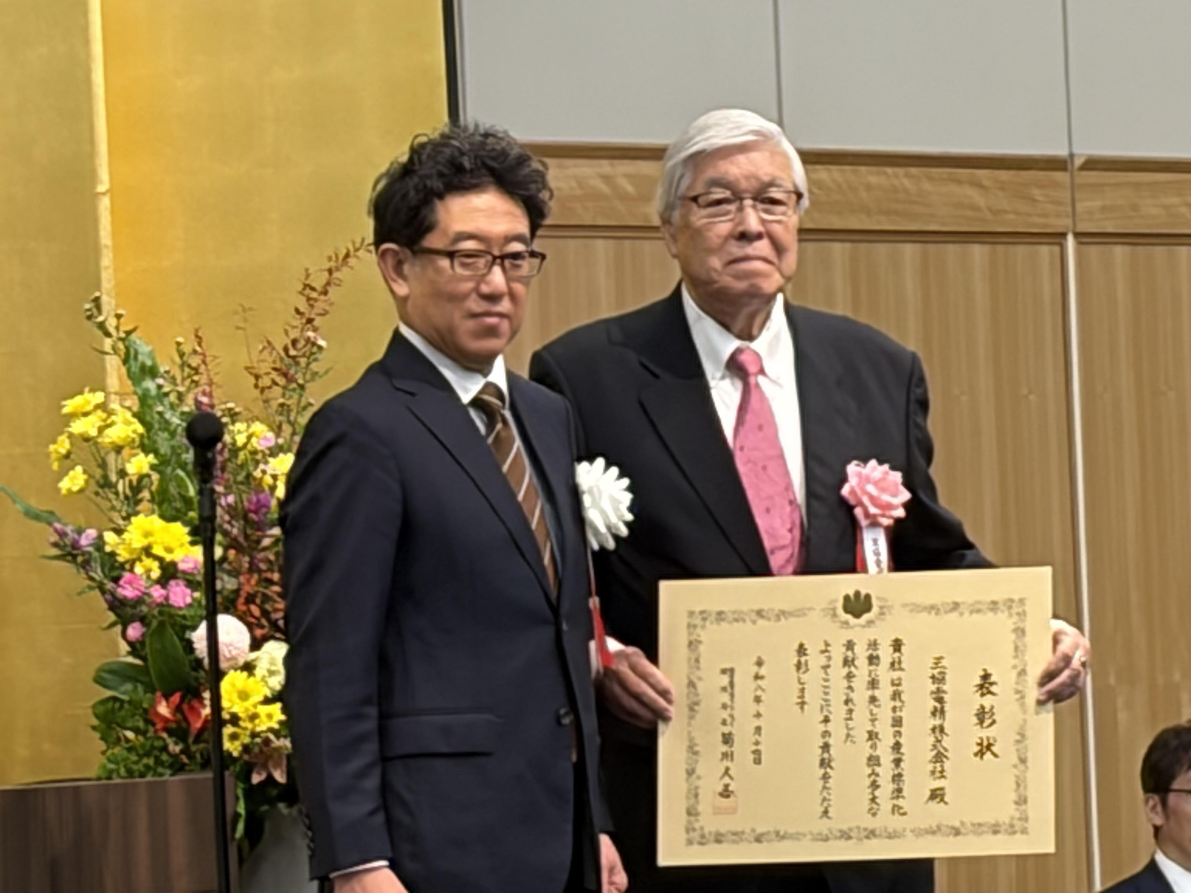 産業標準化事業表彰の表彰式で、表彰状とともに撮影された記念写真
