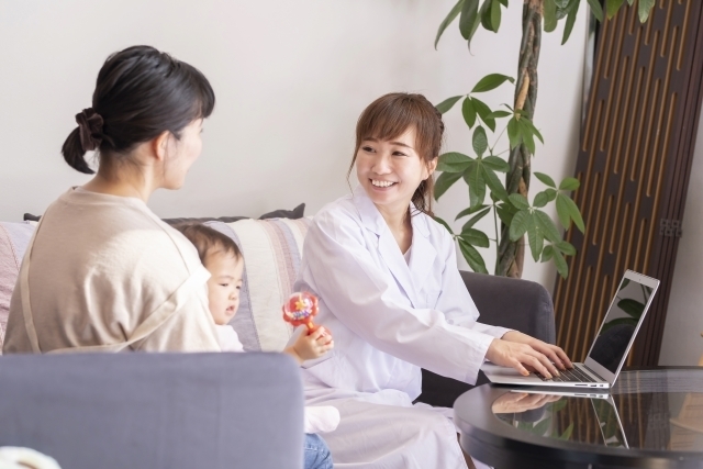 子供と母親に訪問看護をする女性の画像