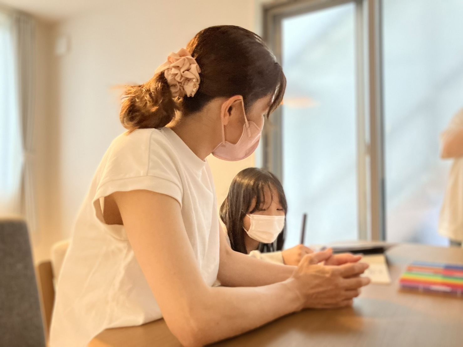 子供の勉強を見ている女性の画像