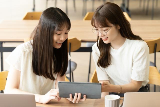 女性2人がお試しホームページの素材や写真・テンプレートを選んでいる