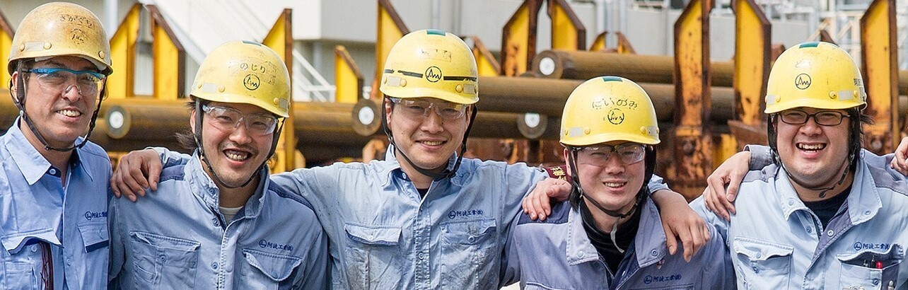 愛知県半田市の工場で和気あいあいと肩を組む作業者