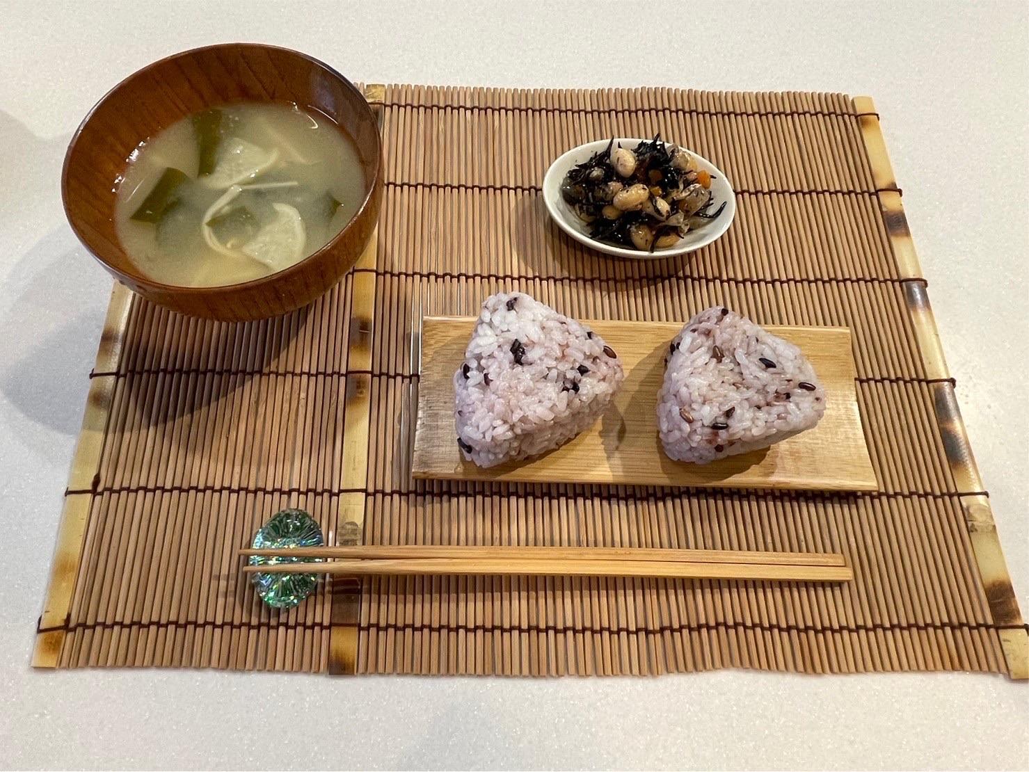 お味噌汁と雑穀のおにぎり、ひじきの小鉢を並べた食卓。
