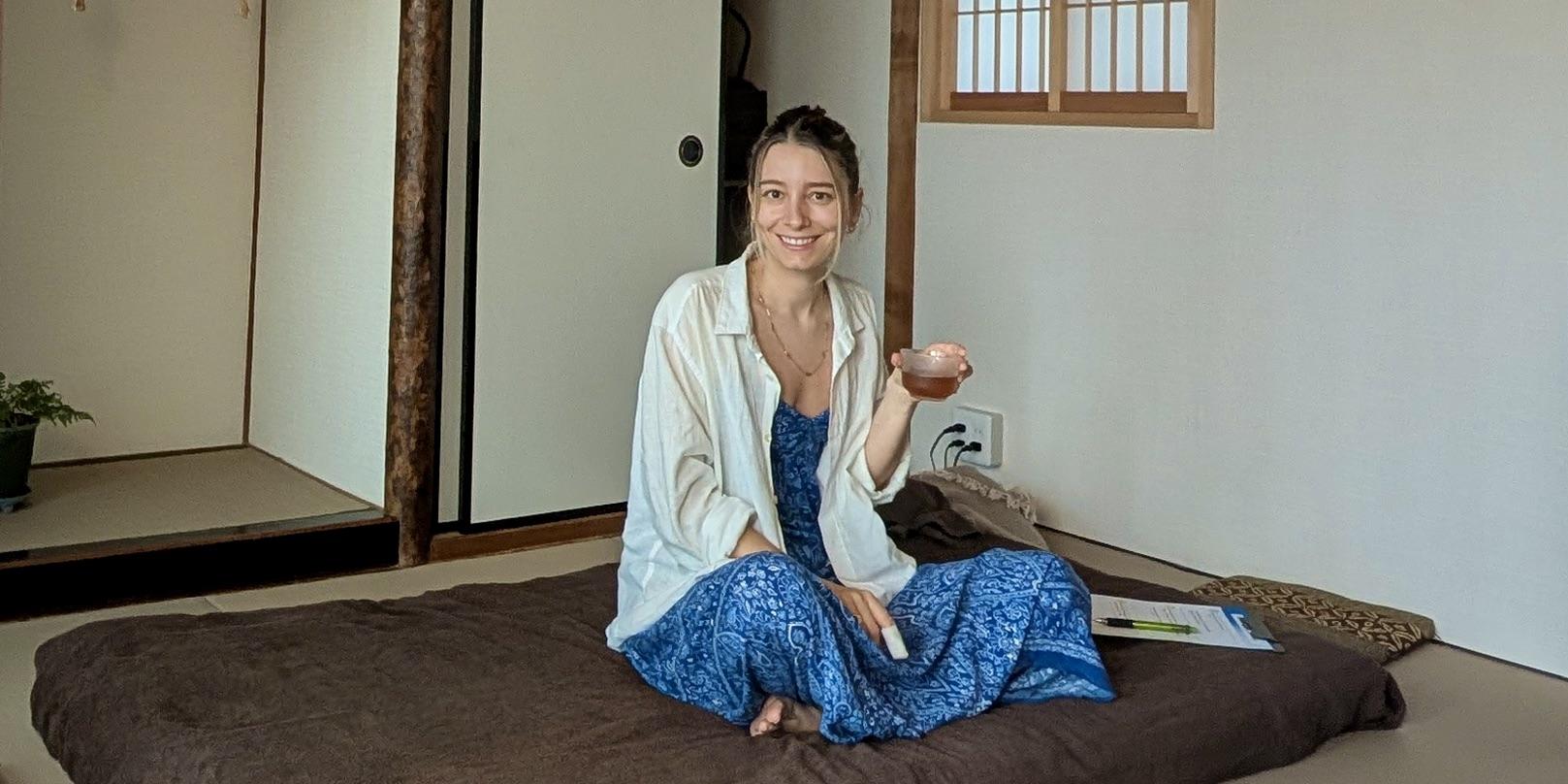 A practitioner placing hands near a client's head during a Reiki session in a traditional Japanese room.