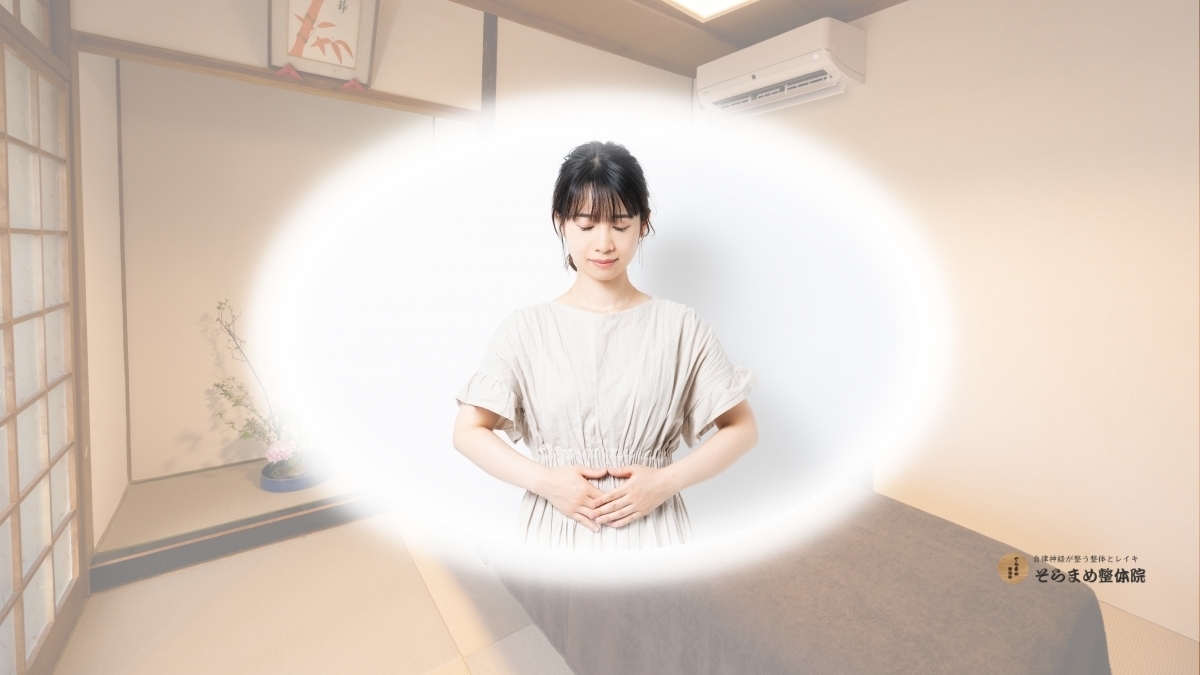 和モダンな落ち着いた和室で、目を閉じて優しくお腹に両手を当てている女性のイメージ画像｜そらまめ整体院健康コラムのブログメイン画像