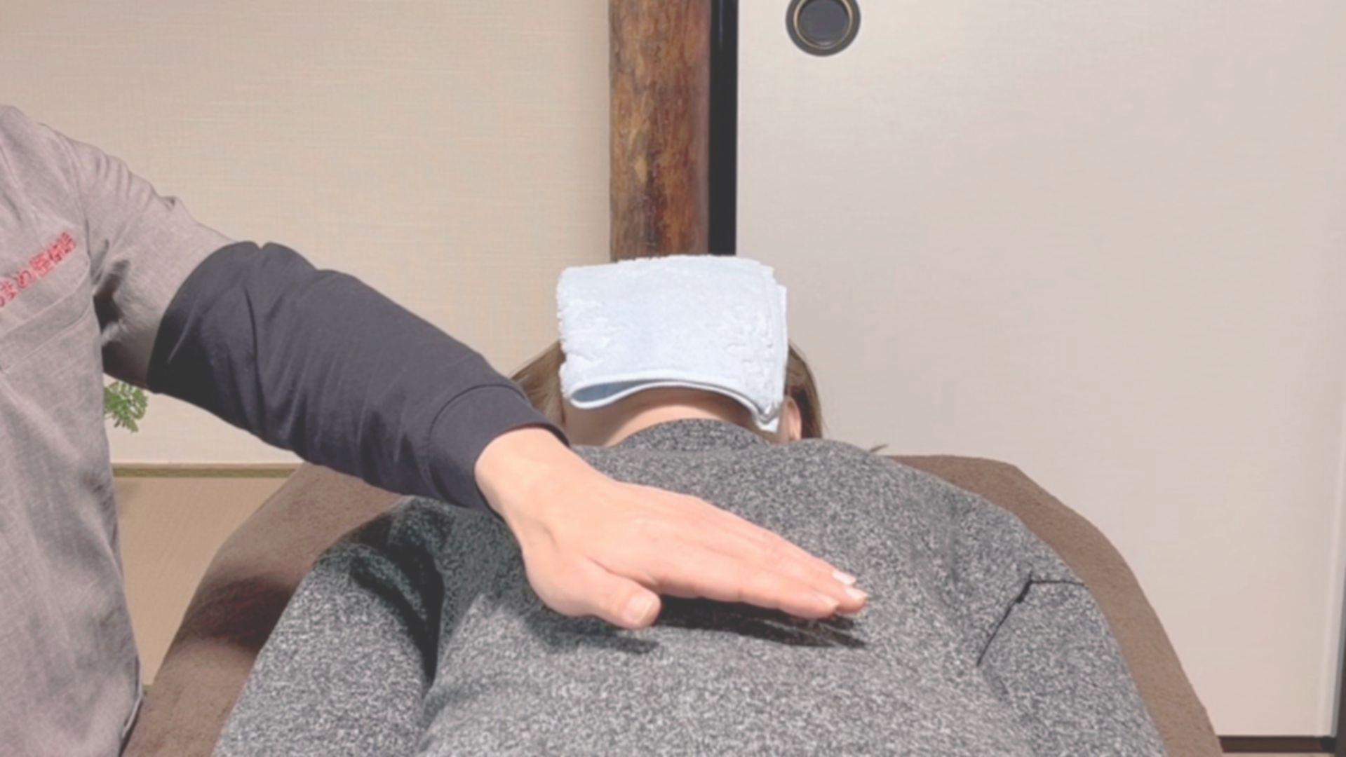 施術者が腹部にそっと手を添え、手のひらの温熱を伝えるレイキヒーリング。内臓の緊張を緩め、自律神経のバランスを本来の調和へと導く様子。