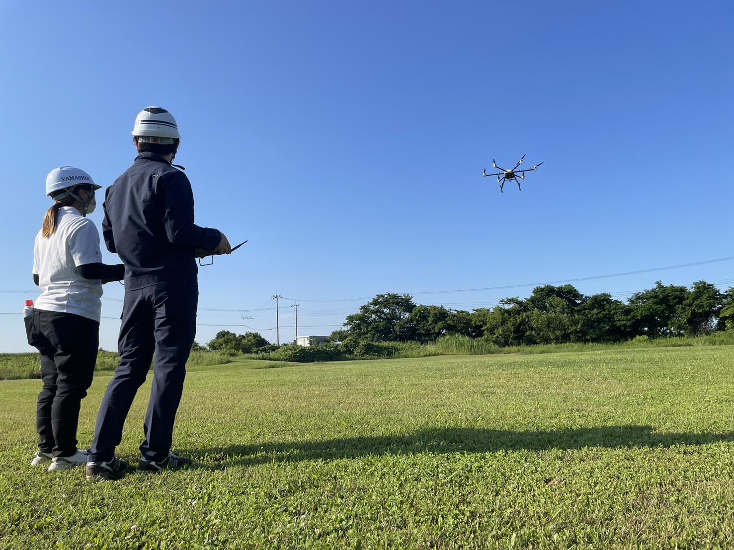 大型ドローンフライトしている2人組