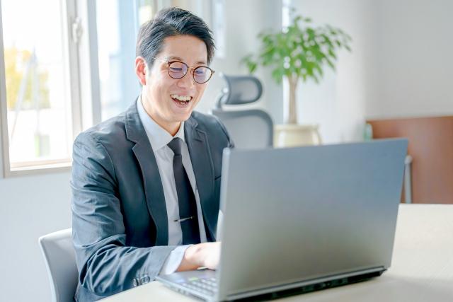 笑顔のパソコンを触る男性