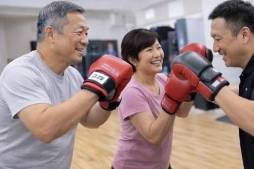 八王子のOSA BOXで50〜70代がミット打ちをしているクラス風景