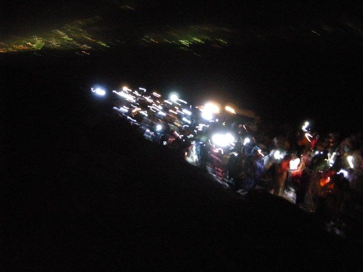 富士山の明け方前の登山道はヘッドライトを灯した人々