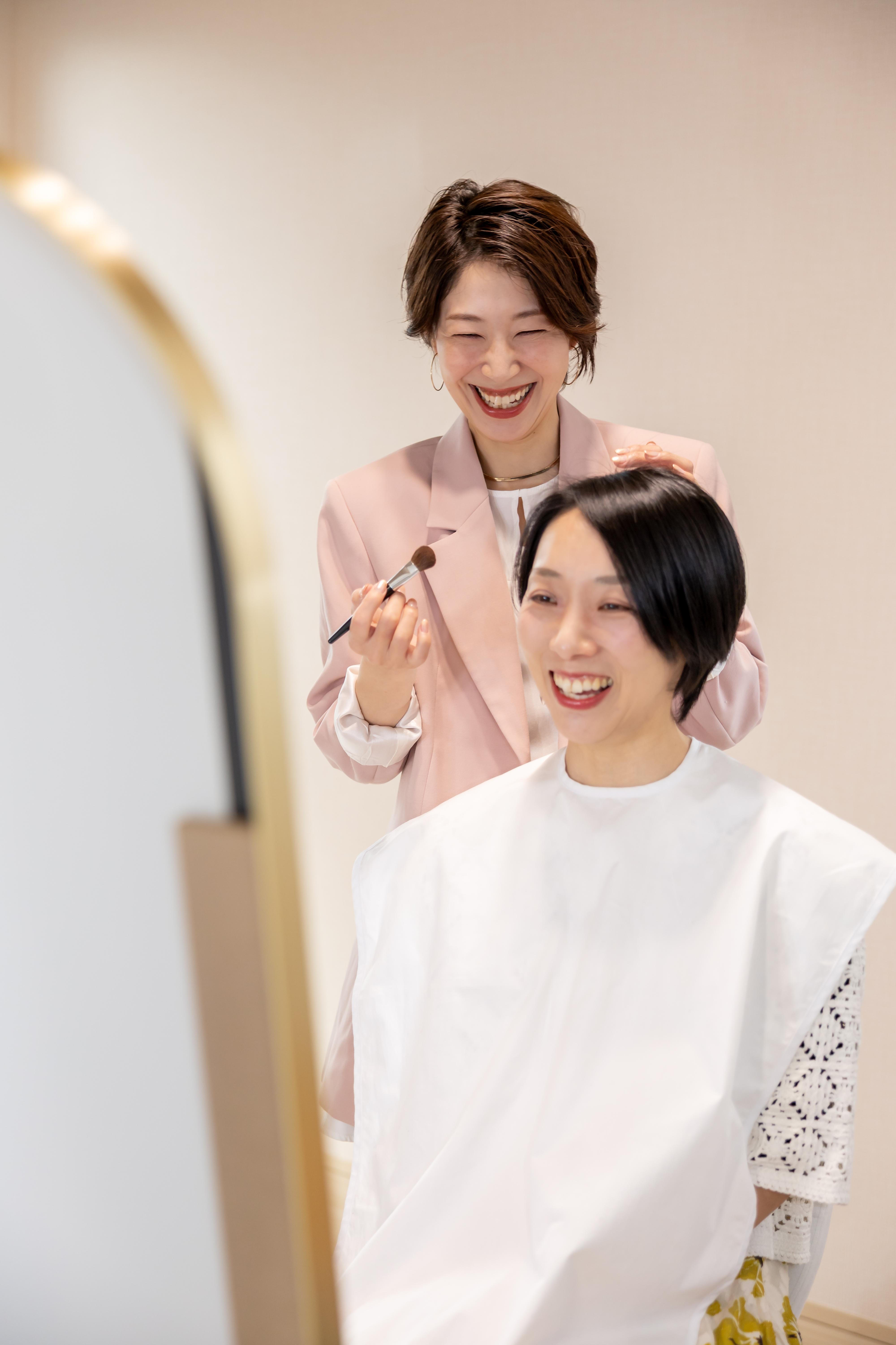 ブラシを持ってメイクレッスンをするameと受ける40代女性のお客様
