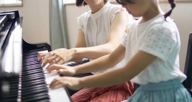 ピアノを弾く少女と女性の画像
