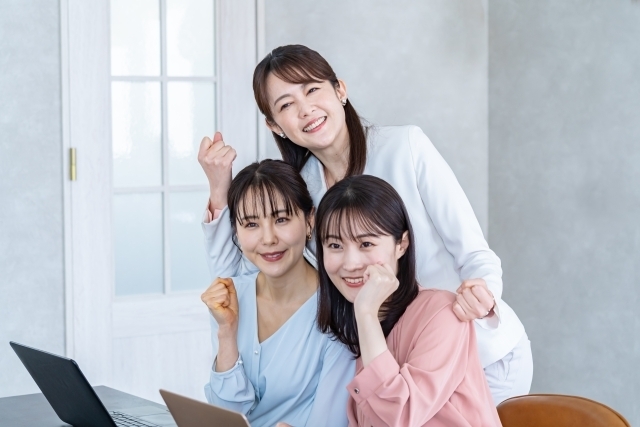 ガッツポーズをする女性スタッフ3人
