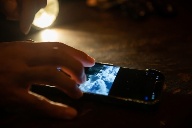 暗い部屋でスマホを触る人