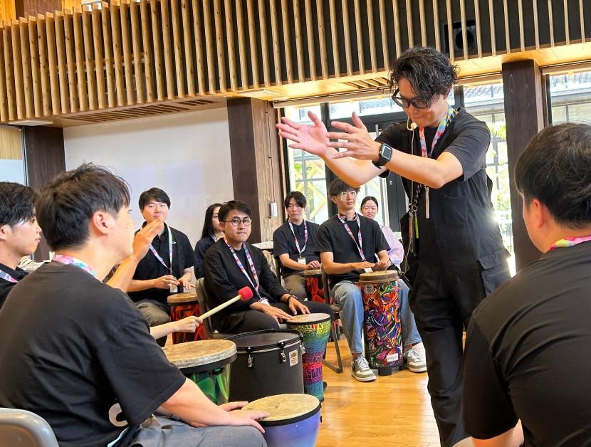 ファシリテーターの合図に合わせて、輪になった参加者がジャンベを叩く様子