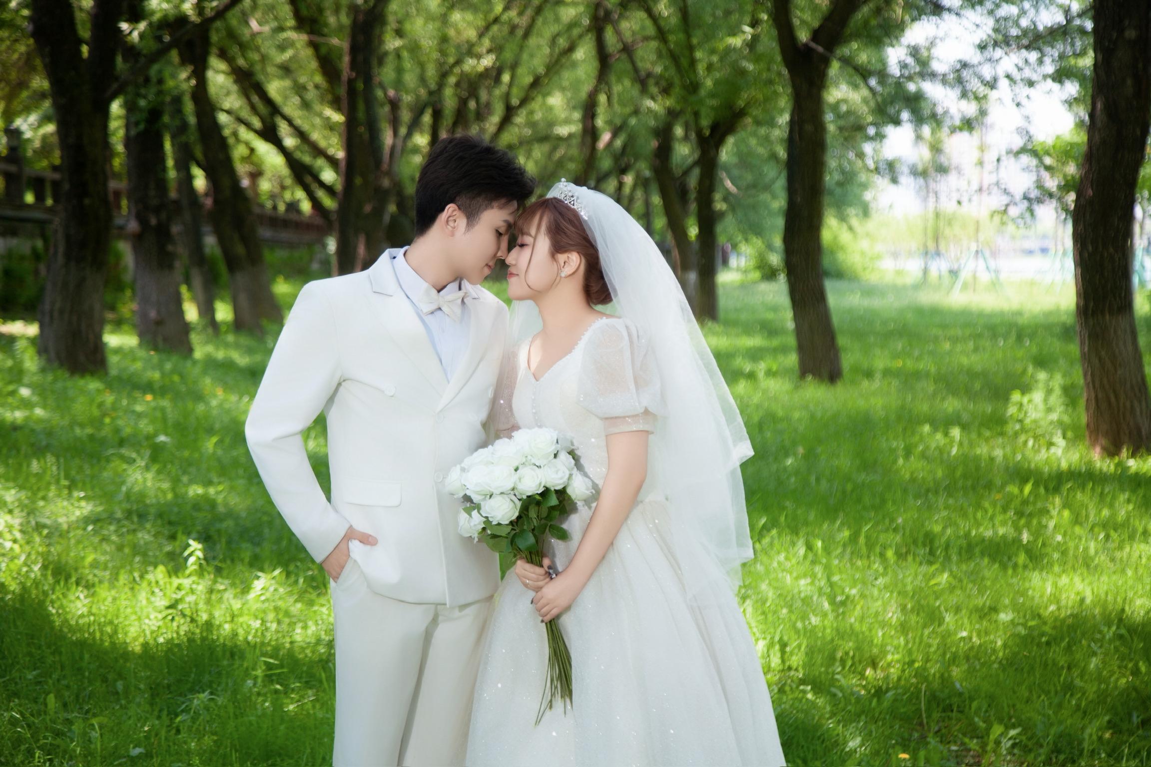 緑の中でブーケを持つ新郎新婦
