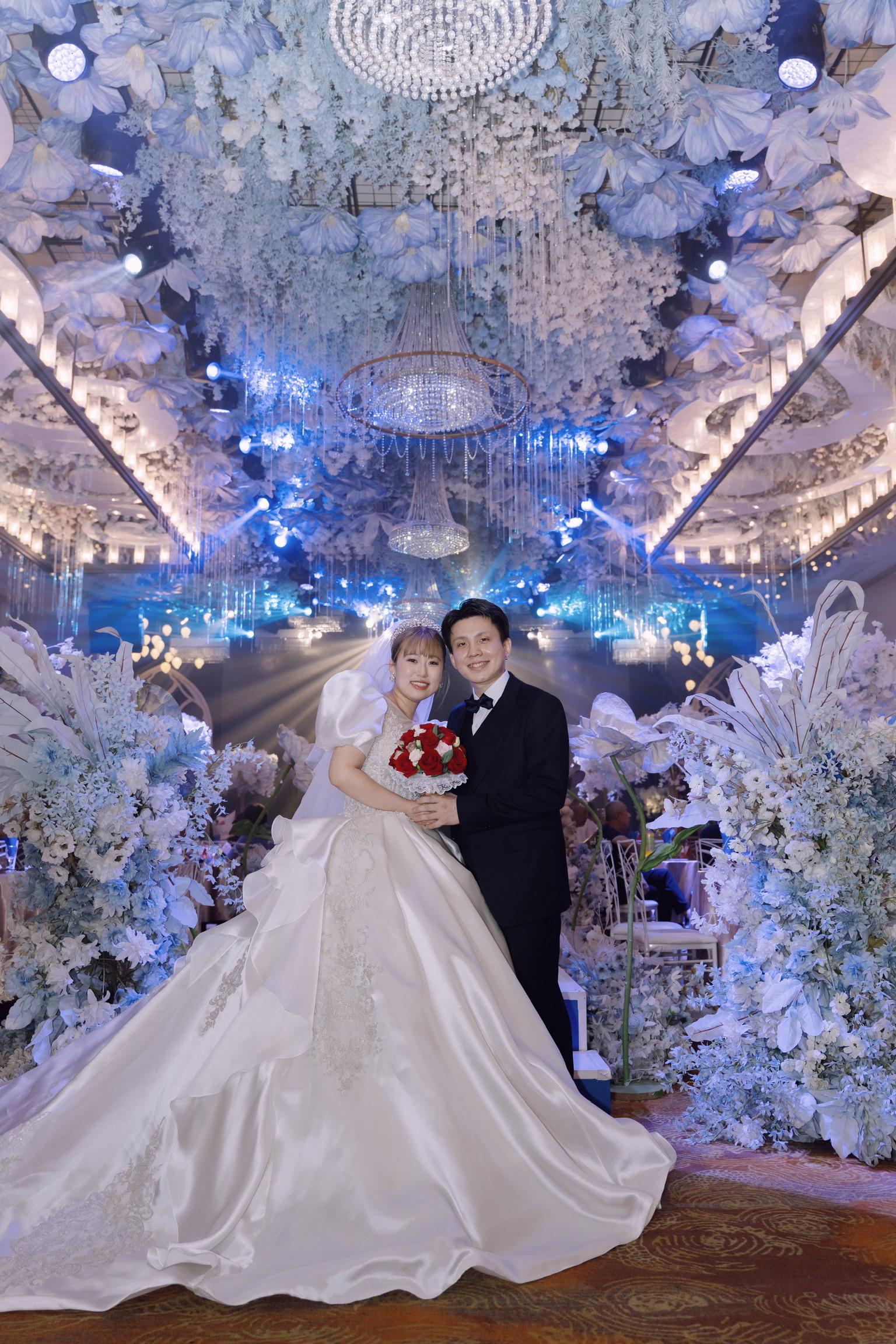 花に囲まれた式場の新郎新婦