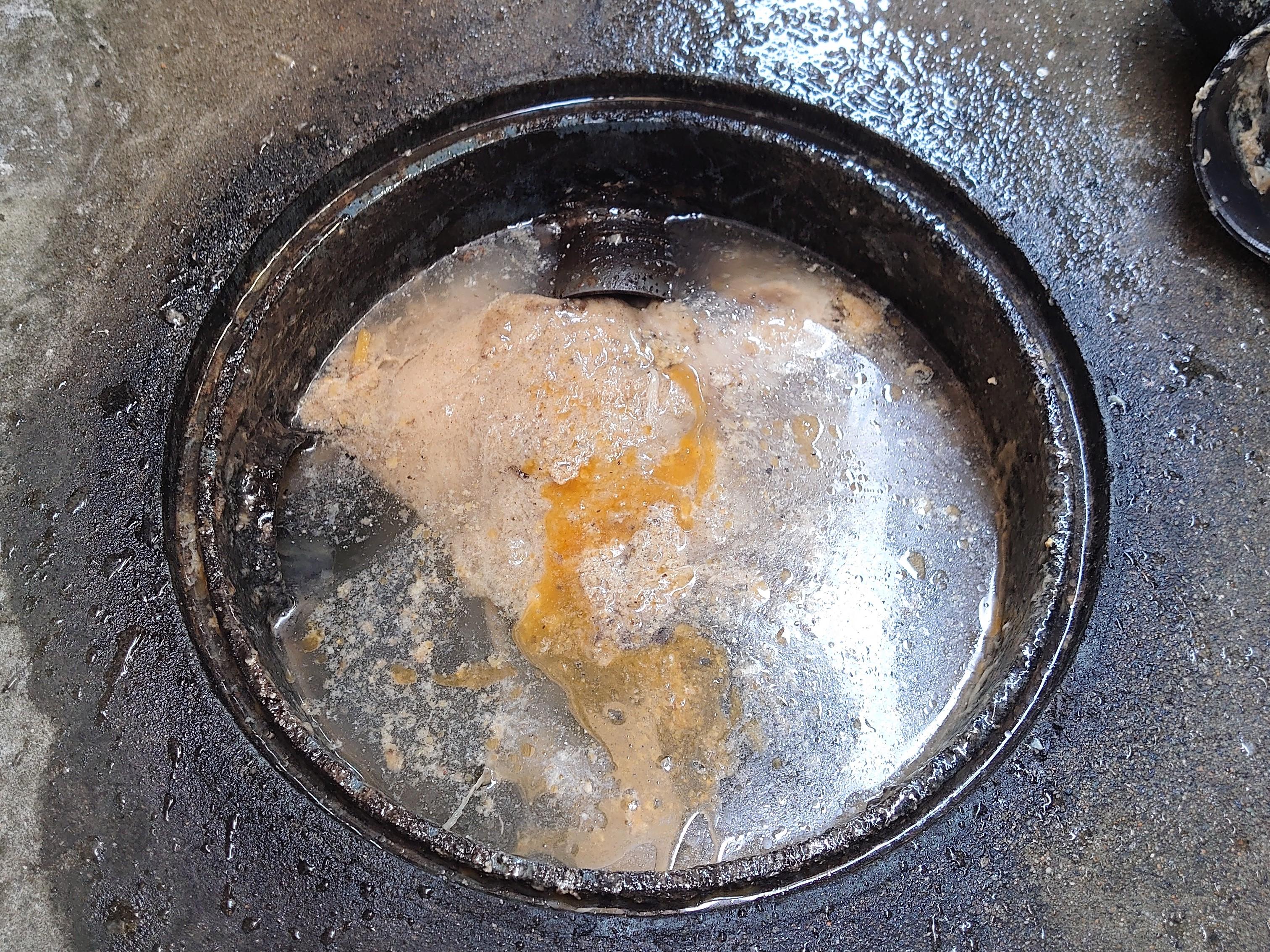 北九州市のバロン消毒。屋外排水桝が油カスで詰まり蓋から溢れてくる戸建のお客様　施工前は油類が桝内に浮いています。